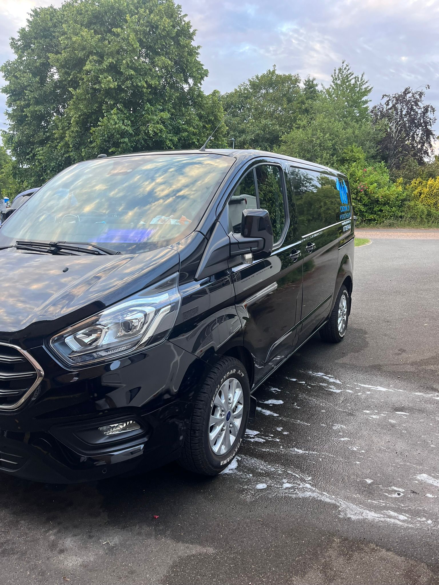 Black van parked on a driveway. cleaned.