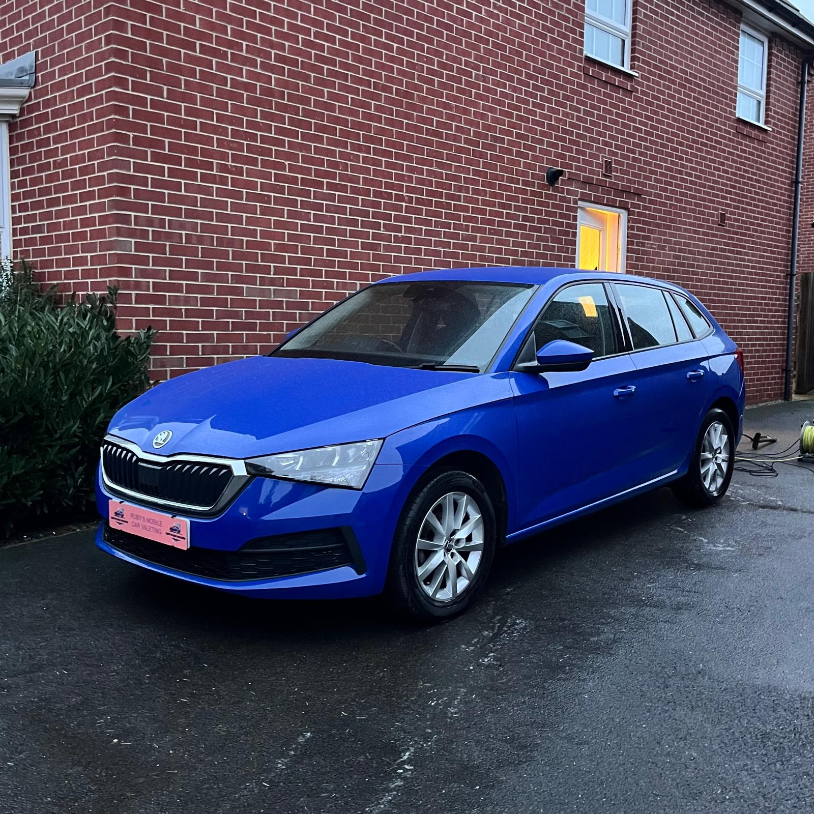 shiny blue car parked on a drive after wash